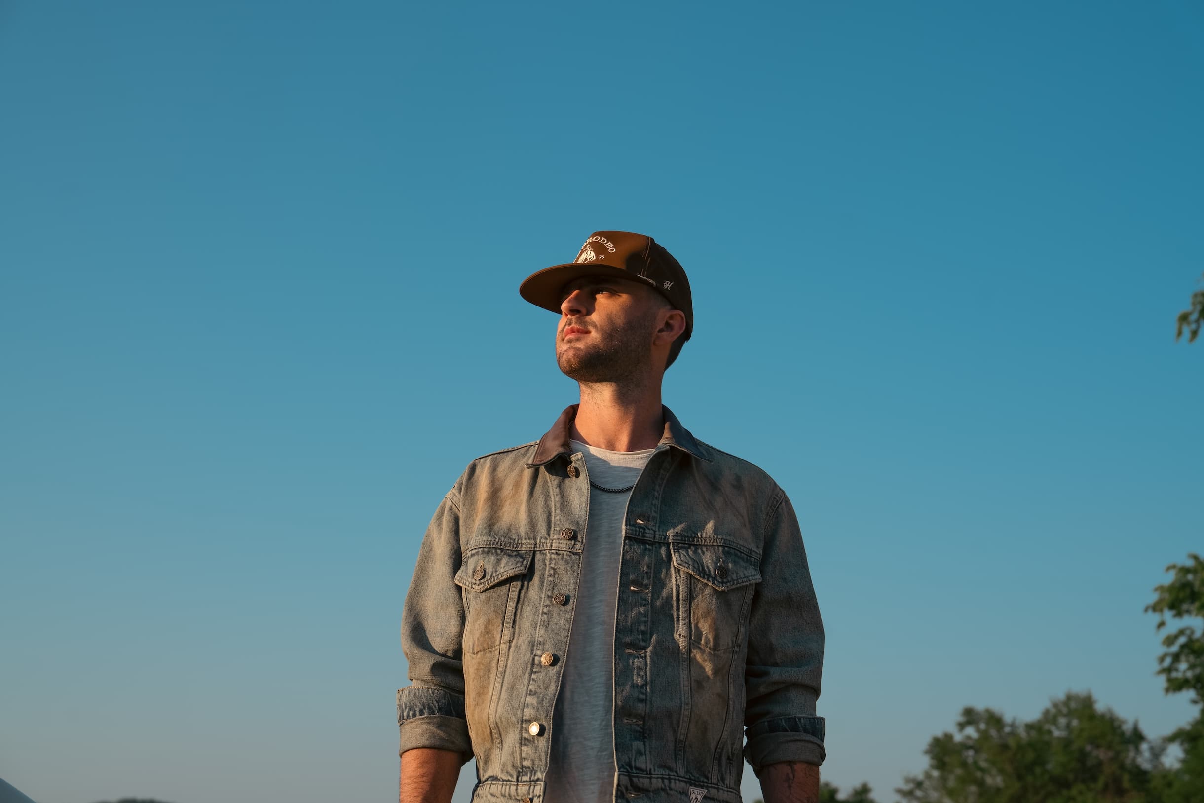 Greylan James in a denim jacket at golden hour
